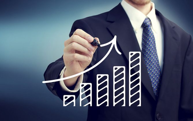 Businessman drawing a rising arrow over the bar graph. Thailand-Property.com