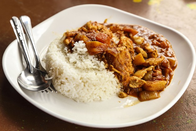 Spicy checking curry on a white plate with a spoon and fork. Thailand-Property.com