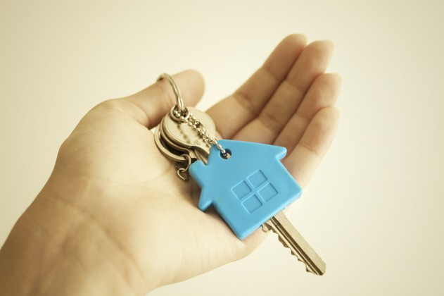 Hand holding a key to a new home.