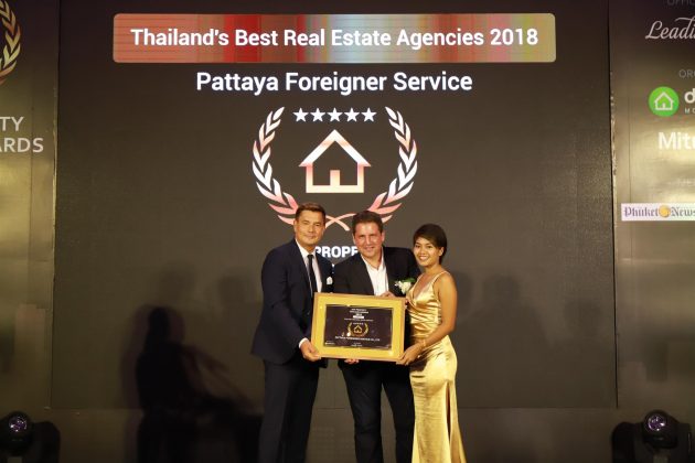 Chris Dietz, vice president of global operationsat Leading Real Estate Companies of the World®, hands the Thailand's Best Agencies award to Paul Cammalleri, owner of PFS, and his partner